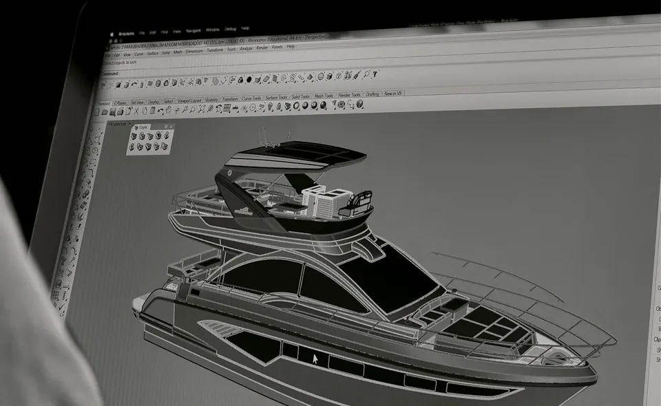 Um projetista do estaleiro diante da tela, com o casco de uma Intermarine em wireframe tridimensional — fotografia de arquivo